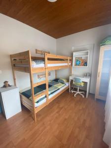 ein Zimmer mit zwei Etagenbetten und einem Schreibtisch in der Unterkunft Casa Lido San Nazzaro in San Nazzaro