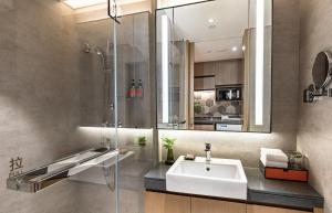 Un baño con lavabo y ducha de cristal. en Citadines Songshan Lake Dongguan, en Dongguan
