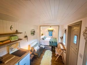 a room with a bed and a room with a couch at Unique Retreat Shepherd's Hut in Robeston Wathen
