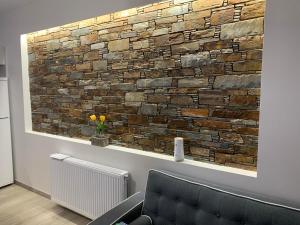 a stone wall in a room with a couch and a chair at Cipollino Place in Karistos