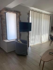 a living room with a chair and a window at Cipollino Place in Karistos