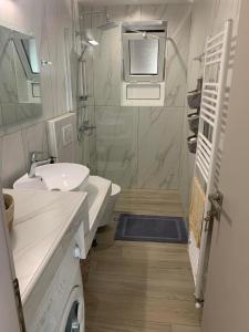 a white bathroom with a sink and a toilet at Cipollino Place in Karistos