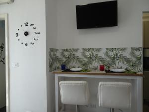 a table with two chairs and a tv on a wall at Suite Romeo-monolocale intimo vicino alle spiagge in Grado