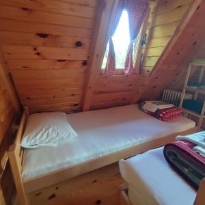 a bedroom with two beds in a log cabin at Seoski Turizam Feniks apartman Davidovi Psalmi in Kosjeric +99 photos