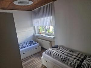a small bedroom with two beds and a window at 3,5 Zimmer Wohnung 68qm in Gladbeck mit Balkon und Stellplatz in Gladbeck