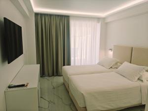 a hotel room with two beds and a window at Ibiscus Hotel in Rhodes Town