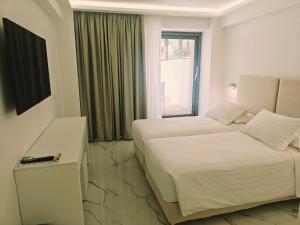 a hotel room with two beds and a window at Ibiscus Hotel in Rhodes Town