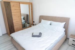 a bedroom with a large white bed with a mirror at Apartman Kruna in Drvar