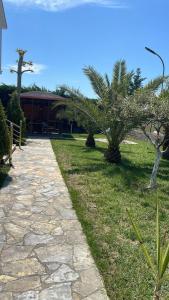 un chemin en pierre devant un bâtiment arboré dans l'établissement Villa Nico - Rent Room, à Golem