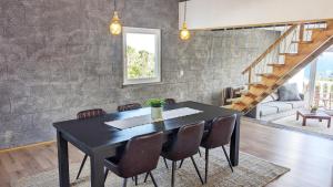 a dining room with a black table and chairs at Villa Capelinhos in Capelo
