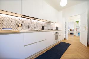 a kitchen with white cabinets and a black rug at Singer House in Center Town in Lucca