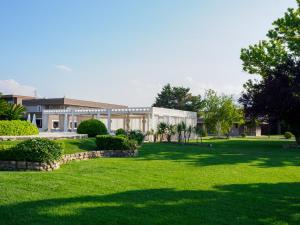 a large building with a green lawn in front of it at Hotel Altamira in Orsogna