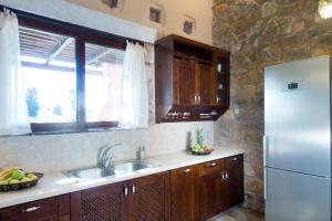 a kitchen with a sink and a refrigerator at Villa Litsarda in Litsárdha +29 photos