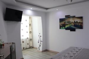 a room with a television and a bedroom with white walls at Apartament Bianca in Năvodari +3 photos