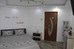 a bedroom with a bed and a wooden door at Apartament Bianca in Năvodari