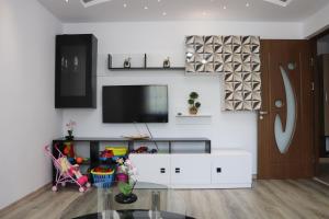 a living room with a tv and a glass table at Apartament Bianca in Năvodari