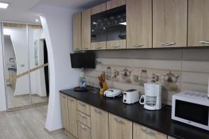 a kitchen with wooden cabinets and a black counter top at Apartament Bianca in Năvodari