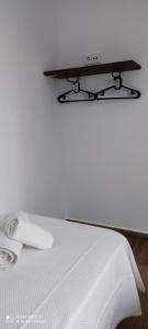 a white bed with a tv on top of it at Apartamentos Bolonia - M a n u e l a in Bolonia