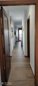a hallway of a house with doors and wooden floors at Apartamentos Bolonia - M a n u e l a in Bolonia