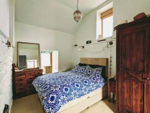 a bedroom with a blue and white bed and a mirror at Secluded Private Cottage Hot-tub, Sauna & Fire-pit in Carrick on Shannon