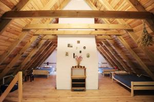 an attic with wooden ceilings and a room with couches at Warmiński dom nad jeziorem in Łomy