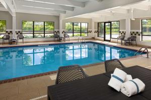 a pool with chairs and tables in a hotel room at Hampton Inn Minneapolis Northwest Maple Grove in Maple Grove