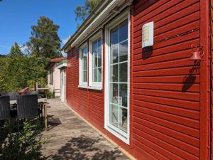 ein rotes Gebäude mit weißen Fenstern und einer Terrasse in der Unterkunft Hellaberg IV Ferienhaus am Waldrand mit Sauna & großer Terrasse in Langenbach