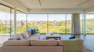 a living room with a couch and large windows at Villa Sea breeze in Bergen aan Zee