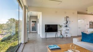 a living room with a couch and a television at Villa Sea breeze in Bergen aan Zee