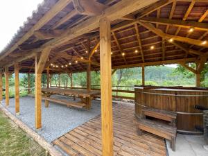 Un gran pabellón de madera con bañera de hidromasaje y una mesa. en Relikvia, en Sovata 14 fotos más