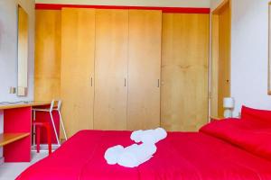 a bedroom with a red bed and wooden cabinets at Villa Angelina - Mare Privato in Cannizzaro