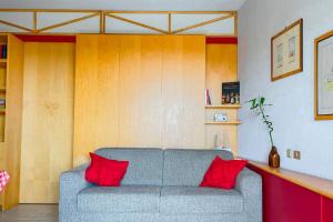 a living room with a gray couch with red pillows at Villa Angelina - Mare Privato in Cannizzaro