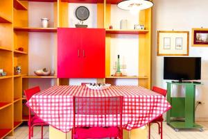a dining room with a table and red cabinets at Villa Angelina - Mare Privato in Cannizzaro +7 photos
