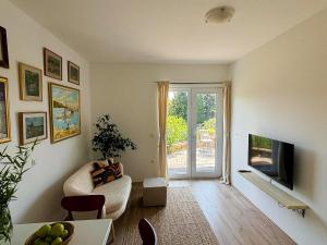 a living room with a couch and a tv at Studio 360 in Portorož