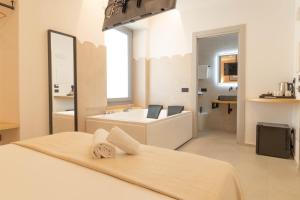 卡利亚里Sardinian Days - Suites & Rooms的一间白色浴室,配有浴缸和洗手池。