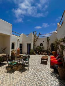 a patio with a couch and a table and chairs at Riad Sahara Sunset Beach Douira Agadir in Douaïra