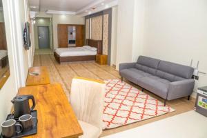 a living room with a couch and a bed at itten plaza blue in Salalah