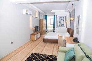 a living room with a couch and a bed at itten plaza blue in Salalah