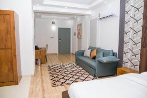 a living room with a blue couch and a bed at itten plaza blue in Salalah