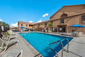 a swimming pool with lounge chairs and umbrellas at MainStay Suites Extended Stay Hotel Casa Grande in Casa Grande