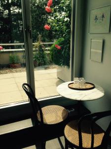 une table et des chaises devant une fenêtre dans l'établissement AVLiving City FLAT Basel with Roof Garden, à Bâle