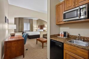 a hotel room with a kitchen and a bedroom at Comfort Inn Fort Myers Northeast in Fort Myers