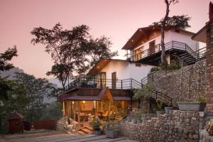a house built on top of a stone wall at Aureva Shaantam Resorts & Spa - Rishikesh in Rishīkesh