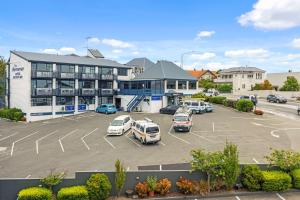 a parking lot with cars parked in front of a building at Comfort Hotel Benvenue in Timaru