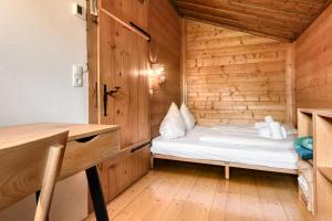 a small room with a bed in a wooden cabin at Haus Haemmerle mit Ski in - Ski out in Damuls