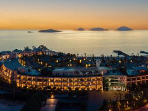 an aerial view of a hotel and the ocean at night at Swissôtel Resort Bodrum Beach in Turgutreis