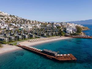 an aerial view of a beach with umbrellas and buildings at Swissôtel Resort Bodrum Beach in Turgutreis