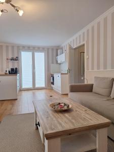 ein Wohnzimmer mit Tisch und Couch in der Unterkunft Haus Ostseenordstern Nienhagen in Ostseebad Nienhagen