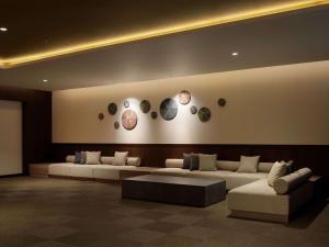 a living room with couches and a table and plates on the wall at Grand Mercure Lake Hamana Resort & Spa in Hamamatsu +55 photos