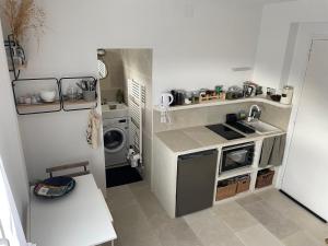a small kitchen with a sink and a washing machine at Gipsy Chic Duplex on the beach in Carolles